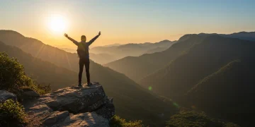 Confident person on mountain top symbolizing self-doubt conquest