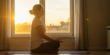 Person meditating peacefully at sunrise, embodying daily joy and mindfulness.
