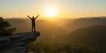 Person confidently overlooking serene landscape at sunrise, symbolizing resilience and mental fortitude.