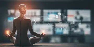 Person meditating calmly amidst digital screens, practicing mindfulness